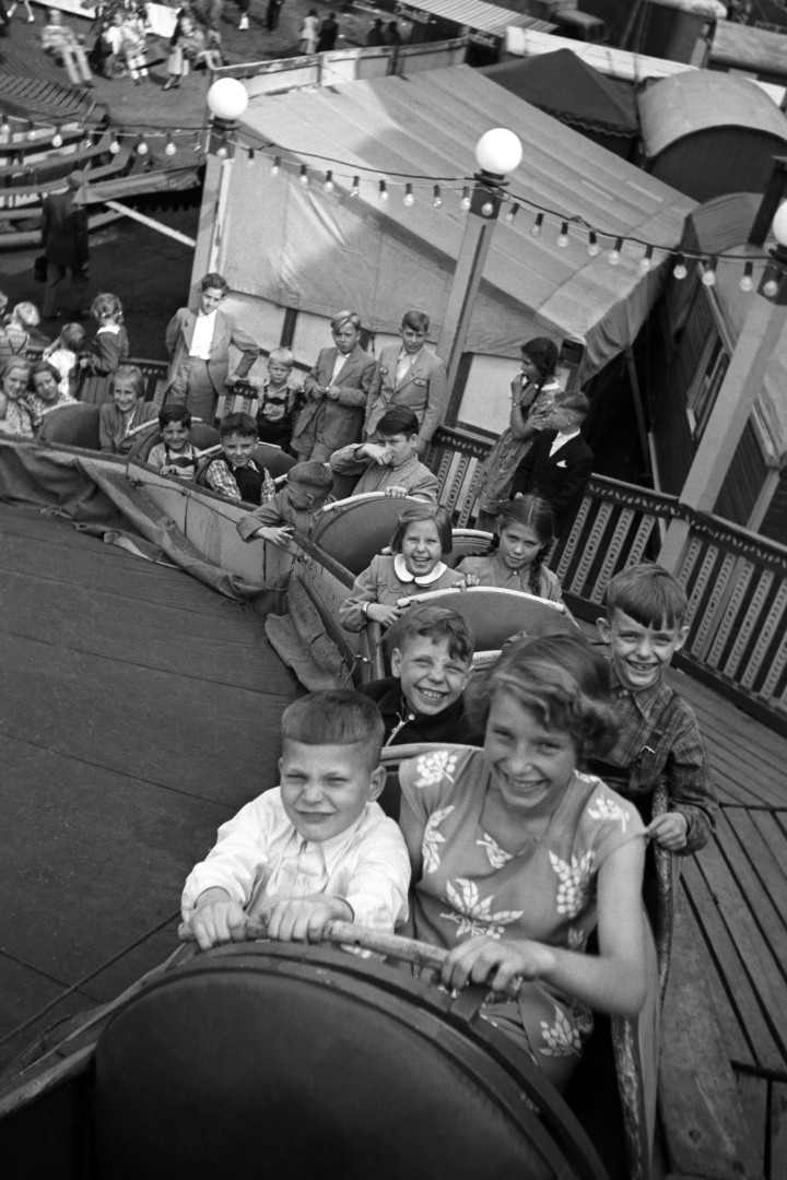 Schwarz/Weiß Aufnahme von Kindern die in einem Kirmeskarussell sitzen