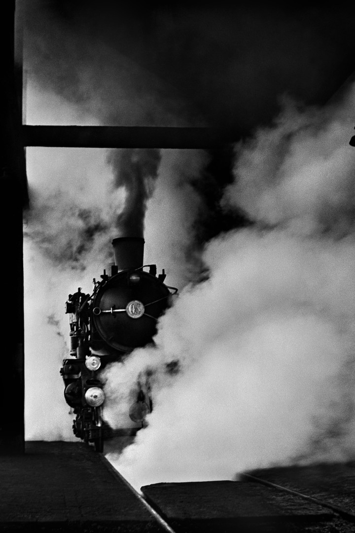 sch/w Foto von René Groebli. Eine Lok ist zentral im Bild. Um sie herum steigt Dampf auf.