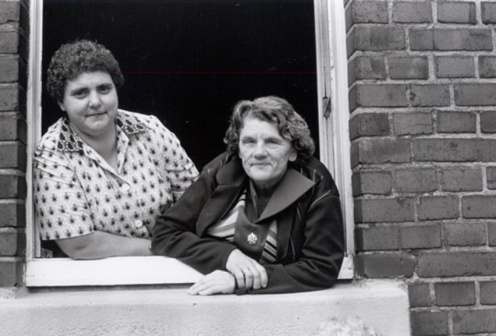 Historisches Schwarz-Weiß-Foto zweier Seniorinnen am offenen Fenster