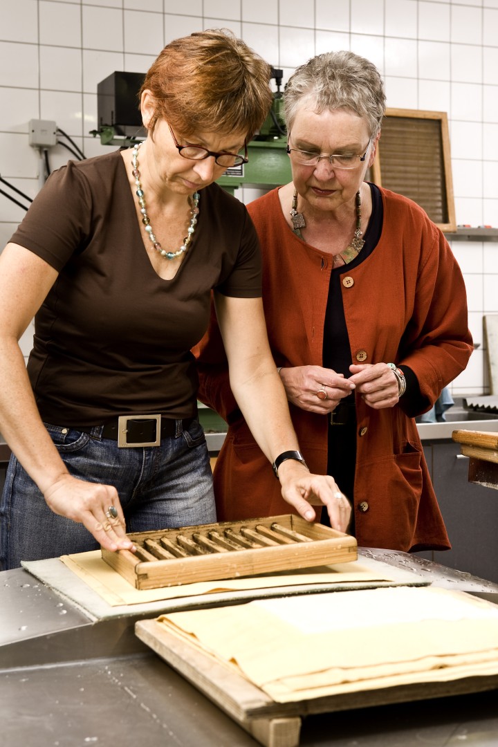 Zwei Damen beim Papierschöpfen