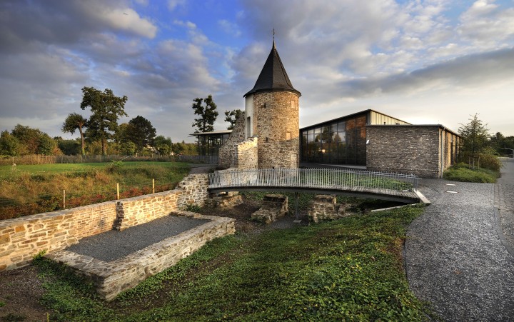 Ein Burgturm hinter einem Teich
