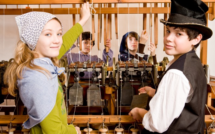 Disguised group of children at a spinning machine