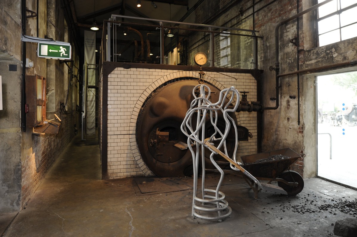 View into the former boiler house with a staging of a working stoker
